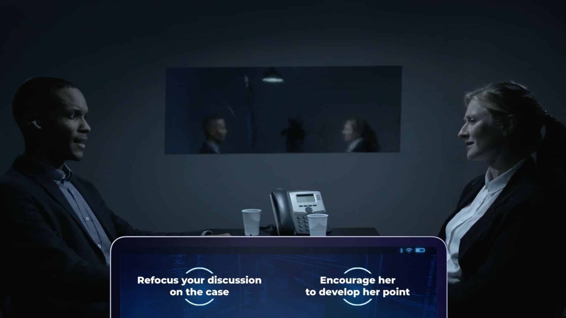 Screenshot from Devogames. A man and a woman face opposit one another in an interrogation room. Two options are presented to the viewer at the bottom of the screen.