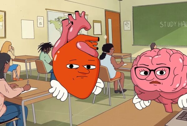 Still from Discovery Education film, Think It Through. Two animated organs, a heart and a brain, look at the audience. In the background, is a high school classroom