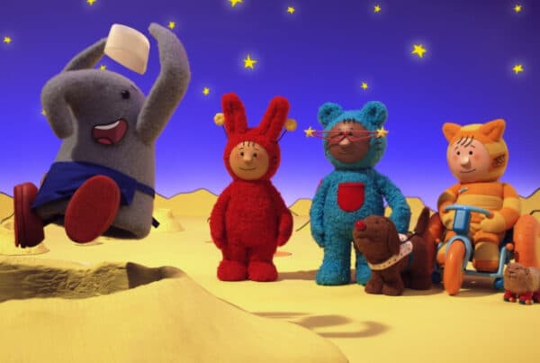 Still from interactive kids media show, Mixmups. Three animated children in playsuits are on the moon. One is in a wheelchair with a dog besides them. They are watching an animated elephant jump into a moon crater.