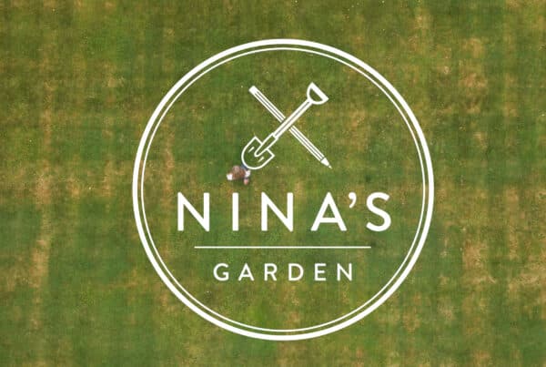 Still from brand video. A birds-eye view of a lawn with the logo for garden design business, Nina's Garden.